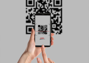 Close-up of a person scanning a large QR code using their smartphone for instant online action.