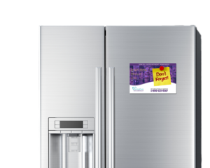 Dental appointment reminder postcard with magnet backing displayed on a kitchen refrigerator.