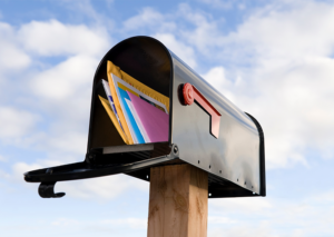 Open residential mailbox filled with colorful mail, representing successful direct mail delivery.
